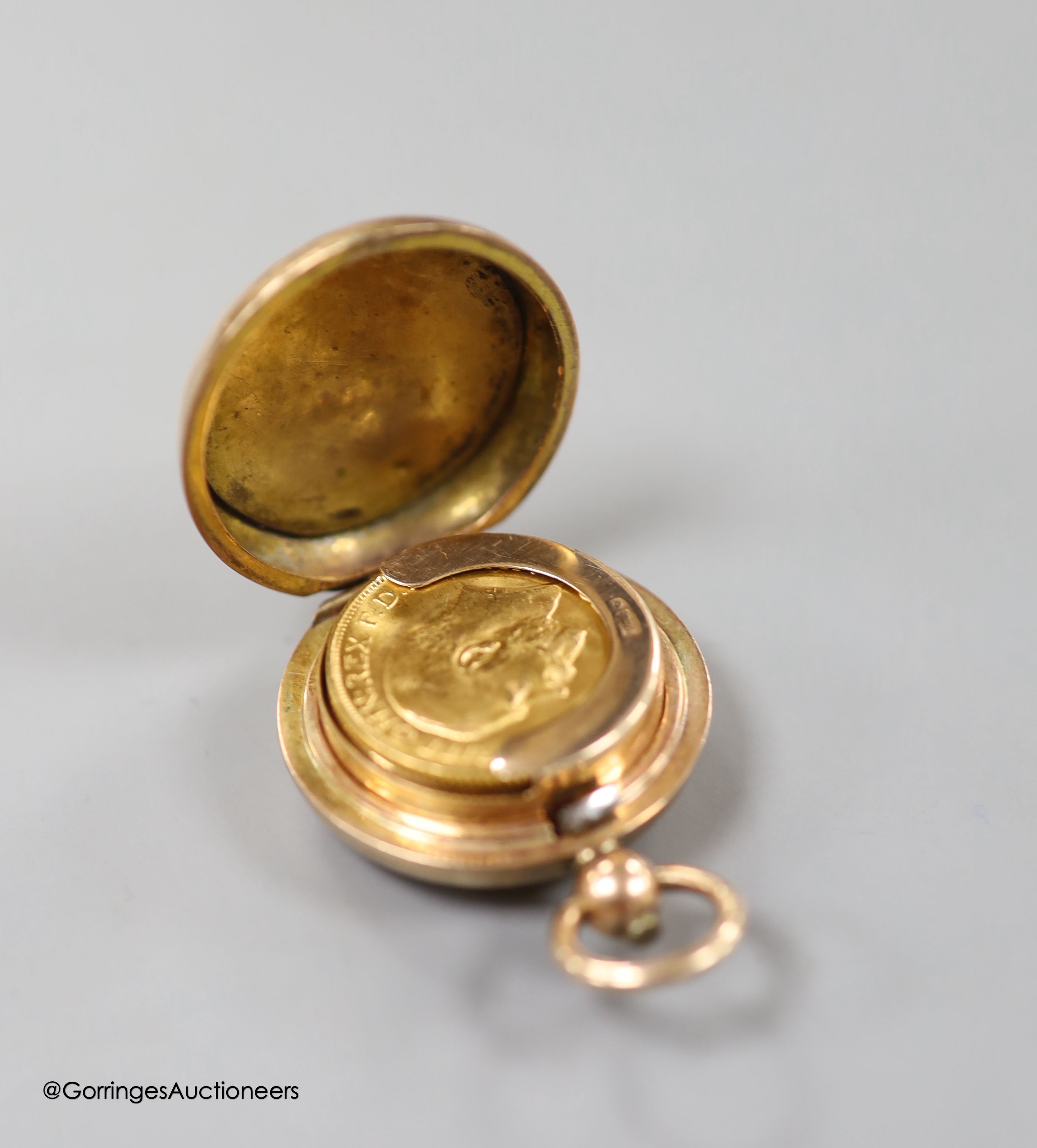 A 9ct gold sovereign case, with engraved monogram, 30mm, gross weight 15.6 grams, containing a George V 1911 gold sovereign